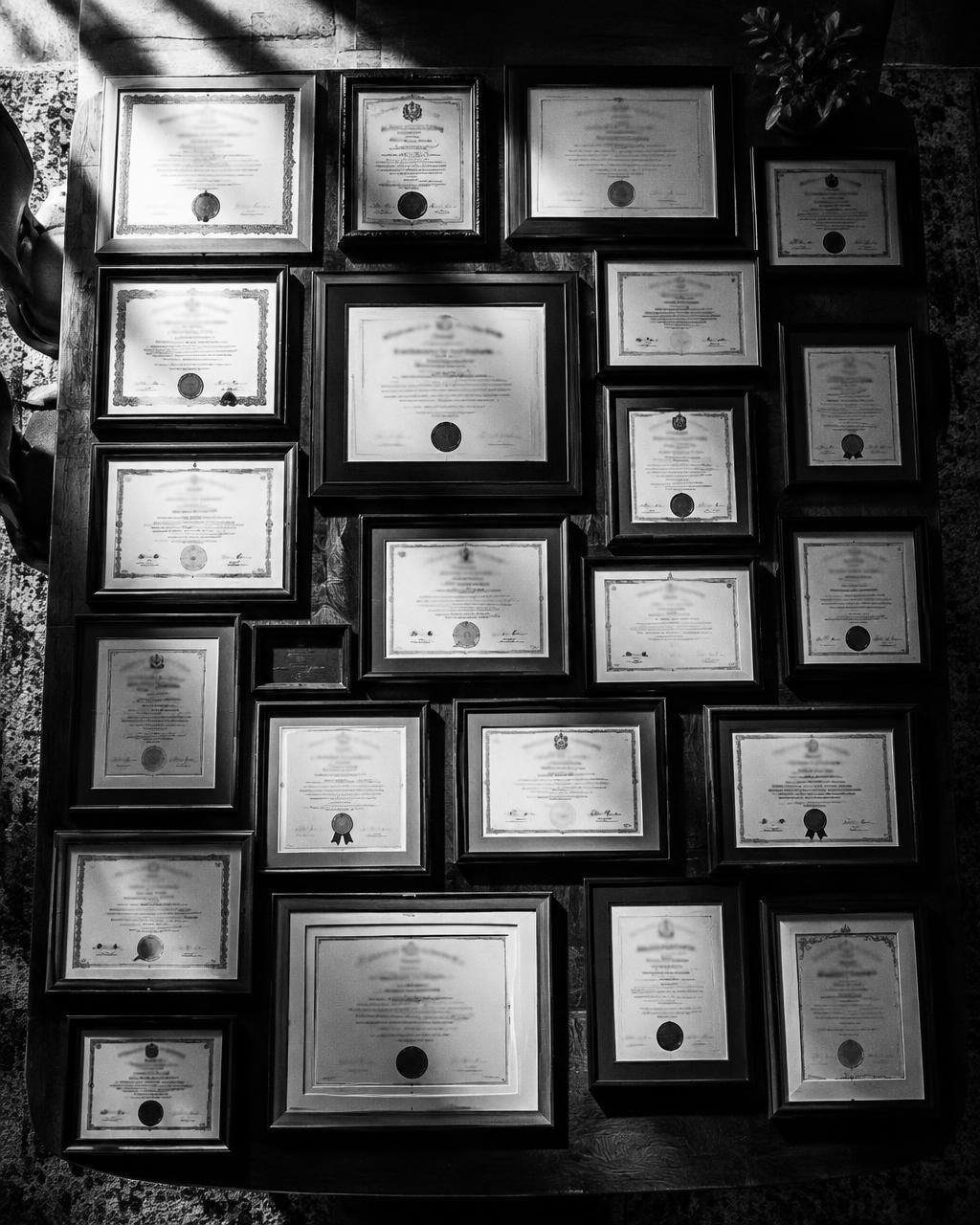 Mesa llena de diplomas enmarcados