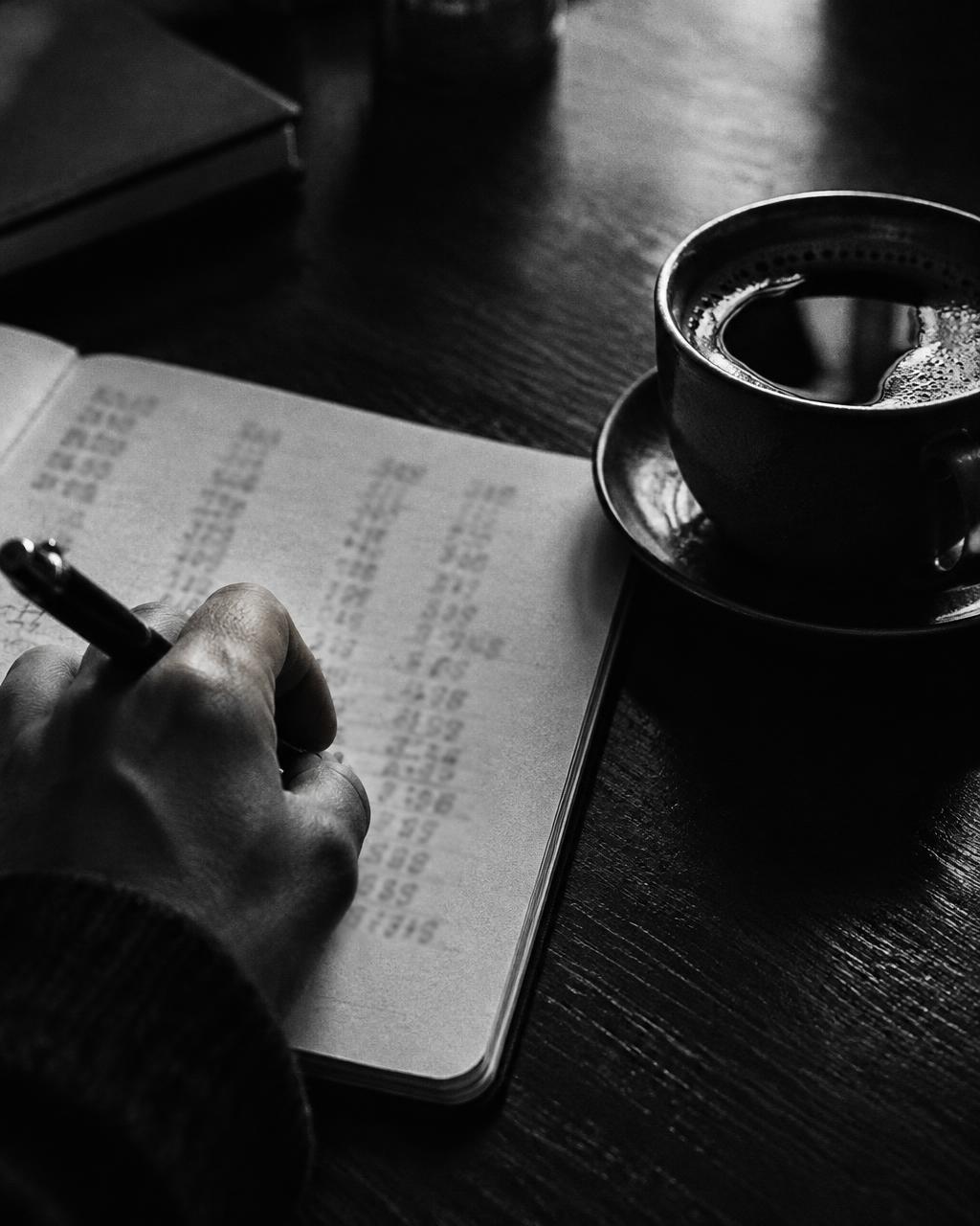 Mano anotando números en un cuaderno